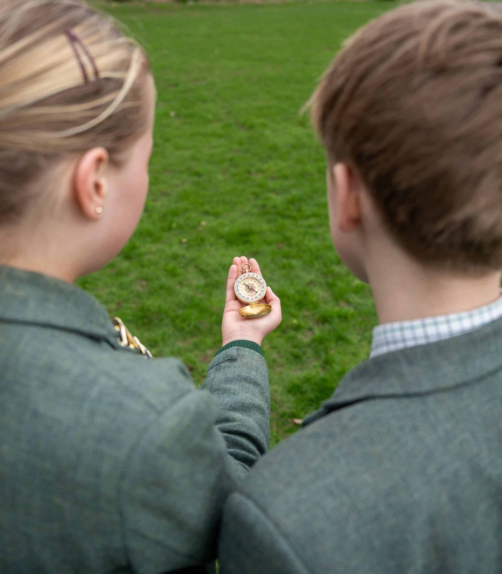a boy and a girl holding a compass.